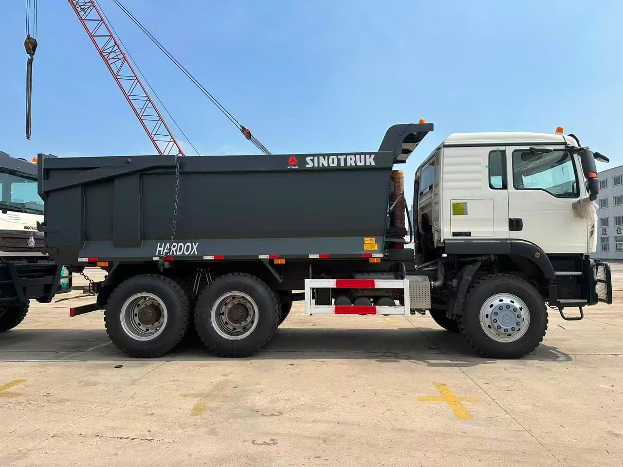 Volquete Sinotruk HOWO blanco de configuración 6x4, vista de perfil, tolva reforzada Hardox
