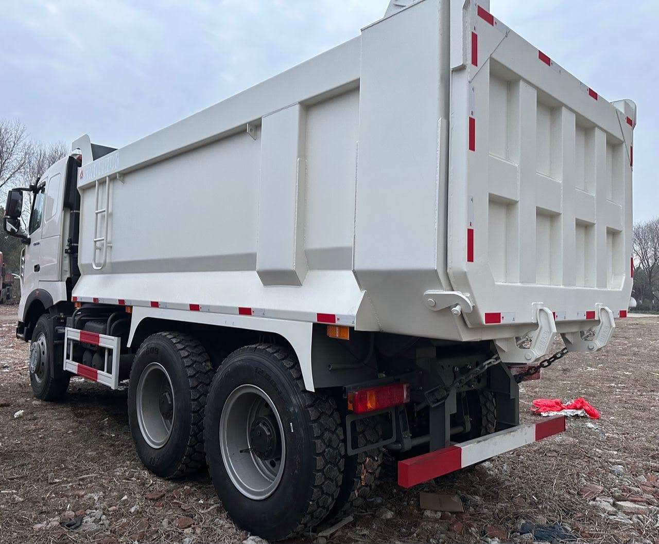 Volquete Sinotruk HOWO TX blanco de configuración 6x4, vista trasera tres cuartos con la tolva